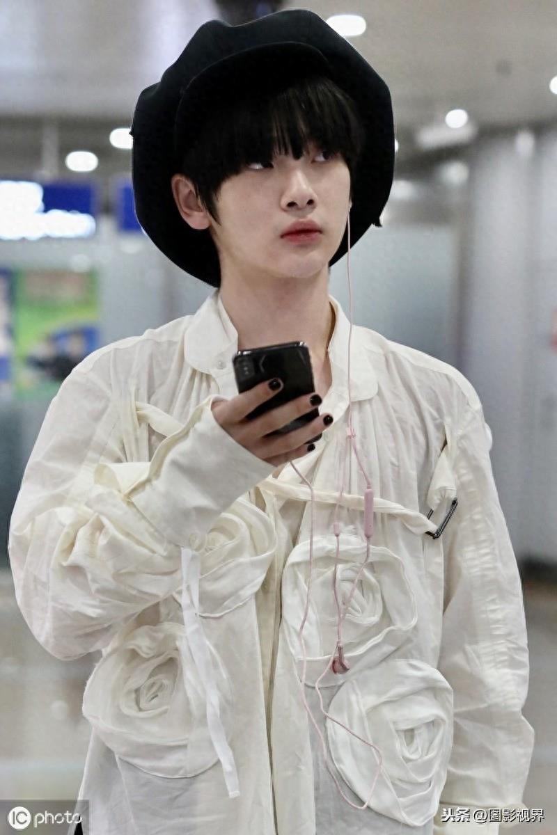 男歌手周震南现身机场,穿白衣服戴贝雷帽,涂黑色指甲油个性十足