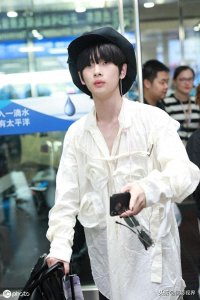 ​男歌手周震南现身机场，穿白衣服戴贝雷帽，涂黑色指甲油个性十足